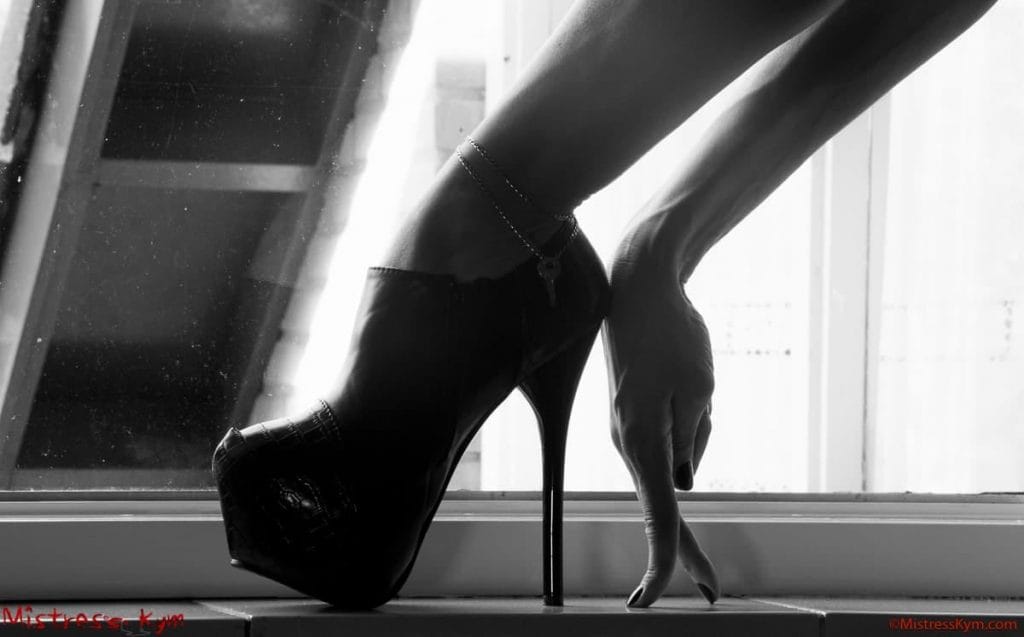 mistress kym high black heeled shoes and her black polished nail hand